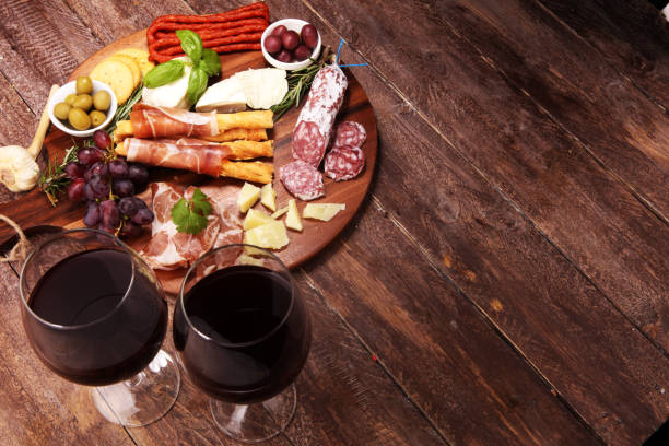 istock antipasto various appetizer. Cutting board with prosciutto, salami, cheese, bread and olives on dark wooden background 1147829822