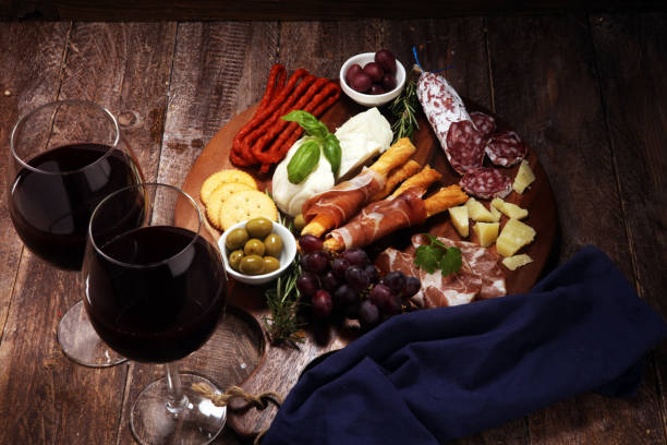 istock antipasto various appetizer. Cutting board with prosciutto, salami, cheese, bread and olives on dark wooden background 1147830610