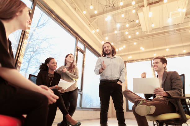 istock Group of coworkers talking together in studio environment 1147831979