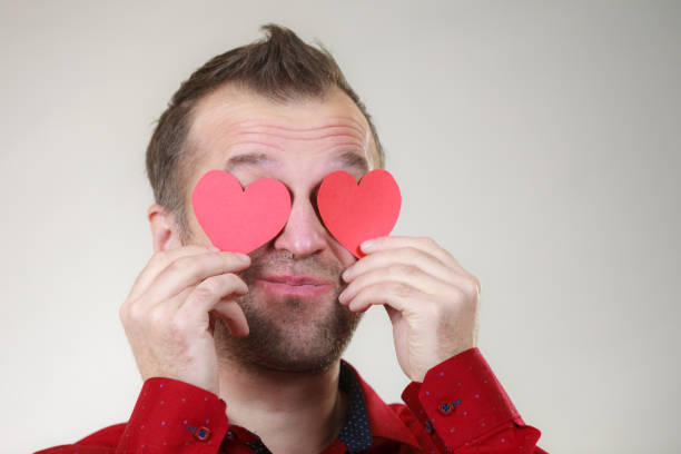 istock Man in love with hearts on eyes 1147833359