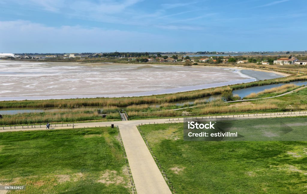 Salt flats in front of Aigues Mortes medieval village, France Salt flats and salins in front of medieval village of Aigues Mortes, France Aigues-Mortes Stock Photo