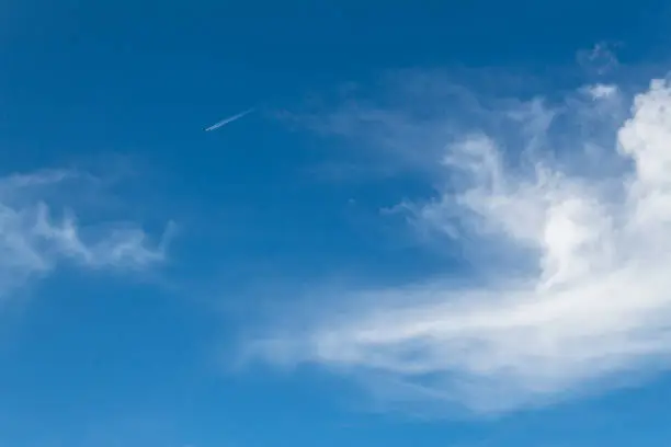 Photo of ground view of commercial airplane looking up view clear sky clouds clarity