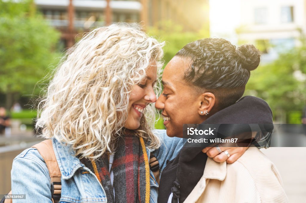Happy multiracial girlfriends in love embracing Happy multiracial girlfriends in love embracing and cuddling - Lesbian couple, millennials women, girls in London living happy lifestyle - LGBTQ concept with mixed race beautiful couple Couple - Relationship Stock Photo