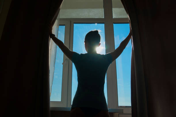 женщина, открываювшая шторы окна - waking up window women morning стоковые фото и изображения
