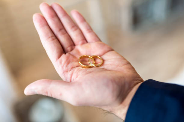 istock Wedding rings. The groom is holding the rings 1147843775