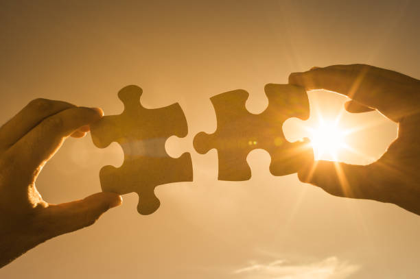 istock Hand putting puzzle pieces together. 1147846982