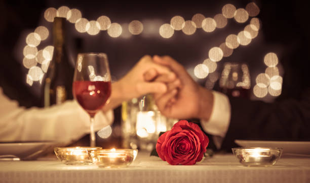 Valentines day. Anniversary. Couple holding hands having a romantic dinner date. soulmates stock pictures, royalty-free photos & images