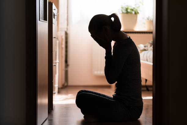 Sad young woman Sad young woman sitting on room floor crying with hand over face crying stock pictures, royalty-free photos & images
