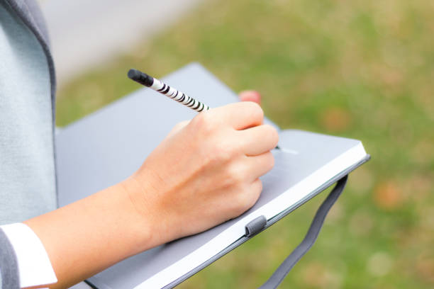 istock Woman's hand is writing in the notebook business idee 1147849559