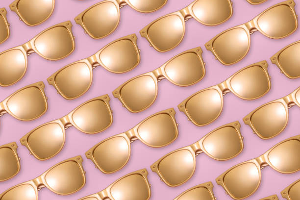 istock Pattern of golden sunglasses on pink background. 1147852365