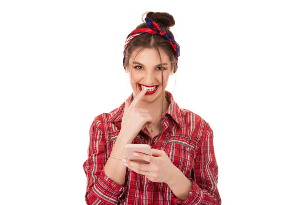 istock Flirting woman holding phone in hands smiling 1147858764