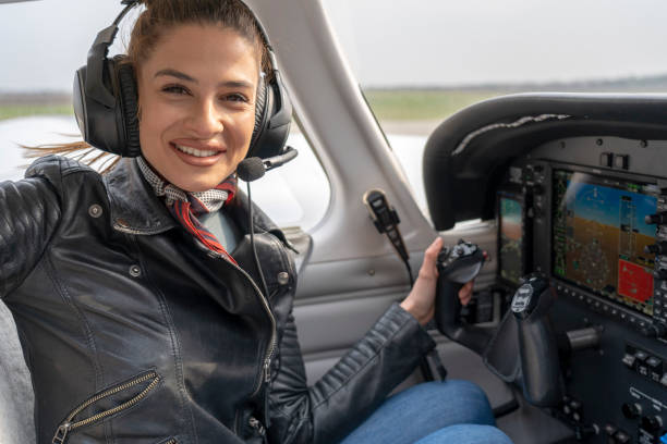 istock Smiling Young Woman Pilot With Headset Sitting in Airplane Cockpit 1147864301