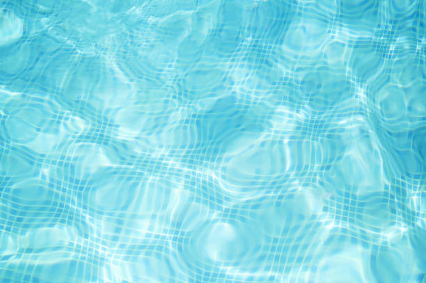 Abstract blue water in swimming pool Abstract blue water in swimming pool with mosaic pattern on bottom at the bottom of photos stock pictures, royalty-free photos & images