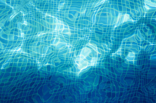 Mosaic tile in blue swimmng pool water texture background