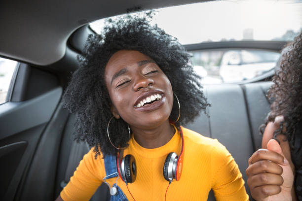 istock Young afro women having fun while dancing during a road trip in the car 1147865354