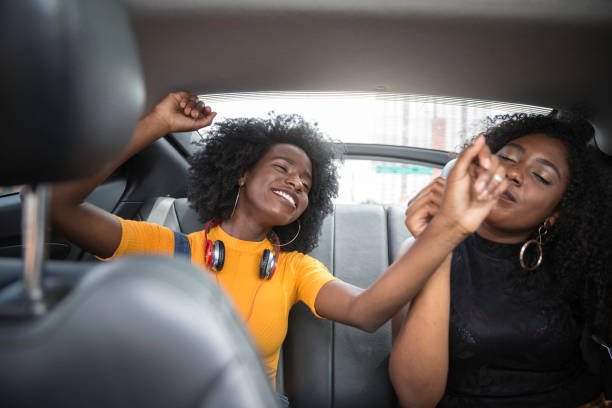 istock Young afro women having fun while dancing during a road trip in the car 1147865532