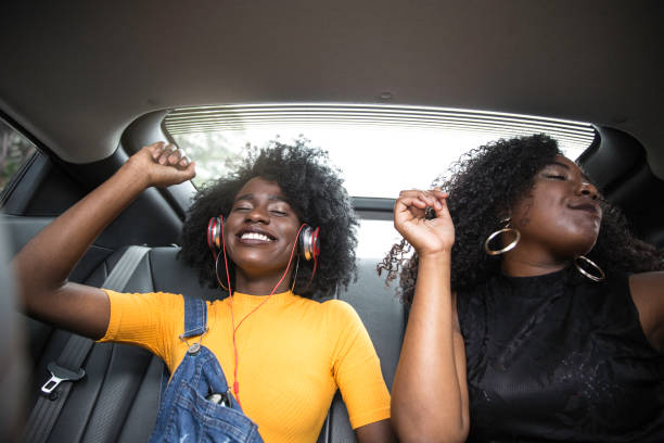 istock Young afro women having fun while dancing during a road trip in the car 1147867738