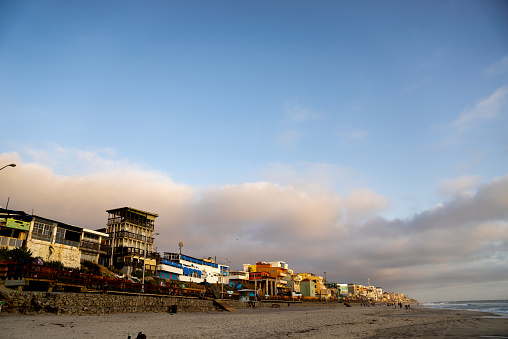 An ocean view drone perspective of the Tijuana beachfront boardwalk and the beautiful oceanside at sunset