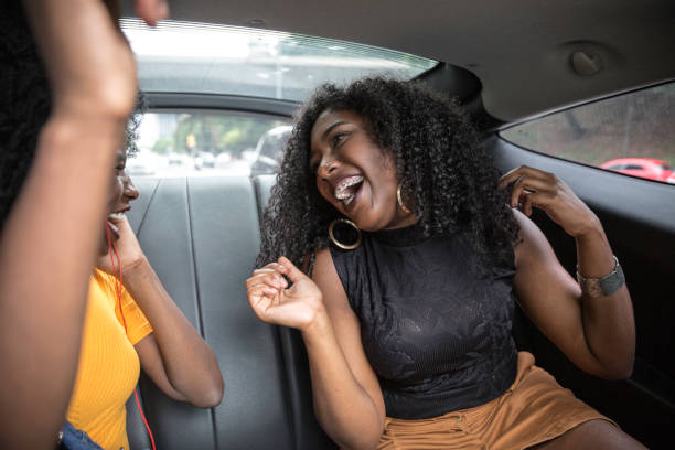 istock Young afro women having fun while dancing during a road trip in the car 1147868602