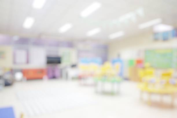 School classroom in blur background without young student; Blurry view of elementary class room no kid or teacher with chairs and tables in campus.
