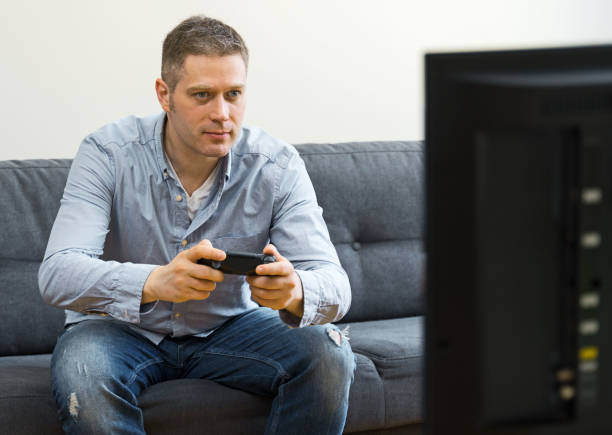 istock Handsome man playing video game at home. 1147881479