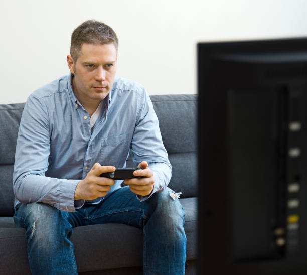 istock Handsome man playing video game at home. 1147881488