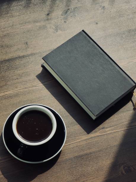 istock Wooden board background with coffee and black books 1147881635