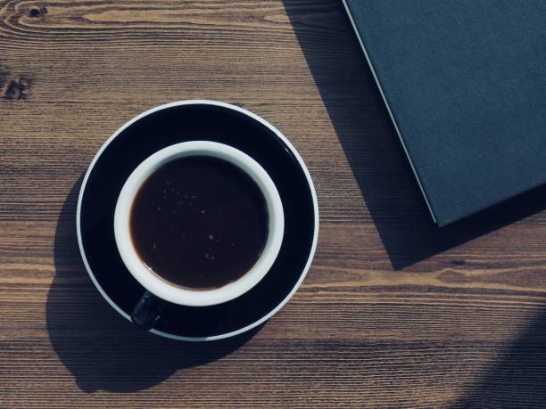 istock Wooden board background with coffee and black books 1147881636