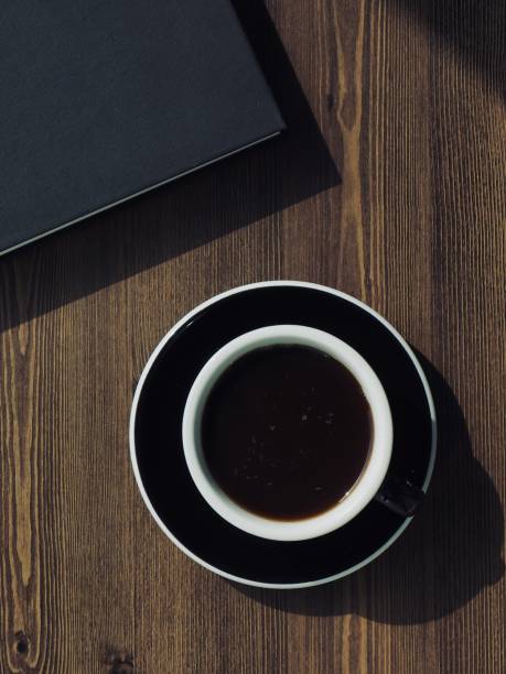 istock Wooden board background with coffee and black books 1147881637