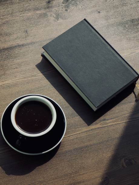 istock Wooden board background with coffee and black books 1147881638