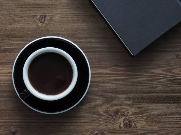 istock Wooden board background with coffee and black books 1147881639