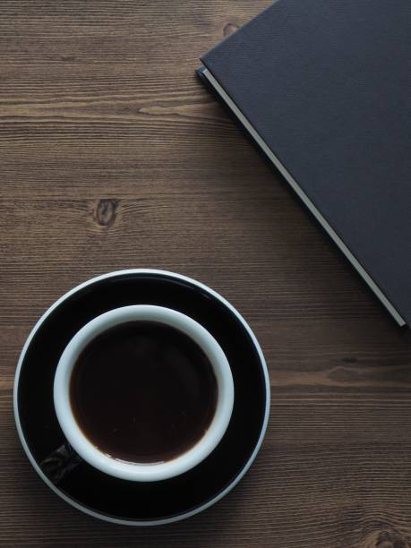 istock Wooden board background with coffee and black books 1147881641