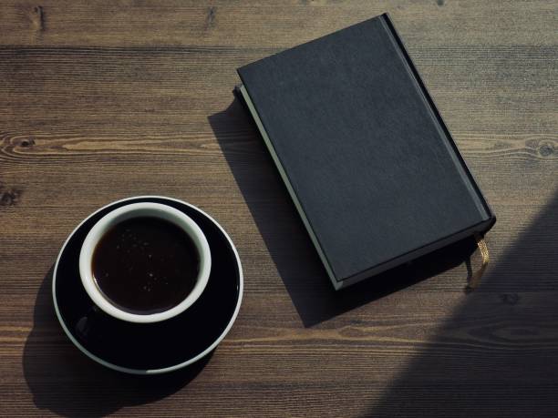 istock Wooden board background with coffee and black books 1147881642