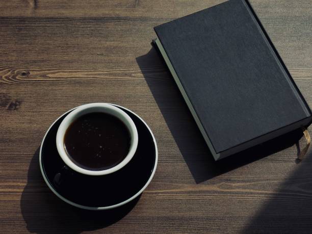 istock Wooden board background with coffee and black books 1147881645
