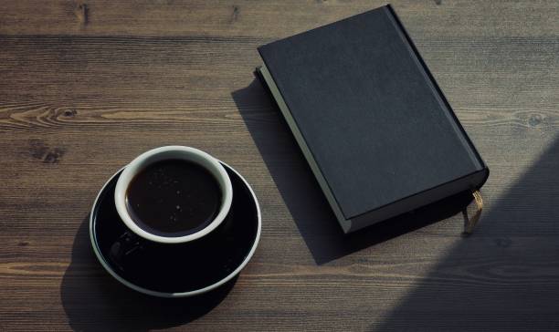 Wooden board background with coffee and black books