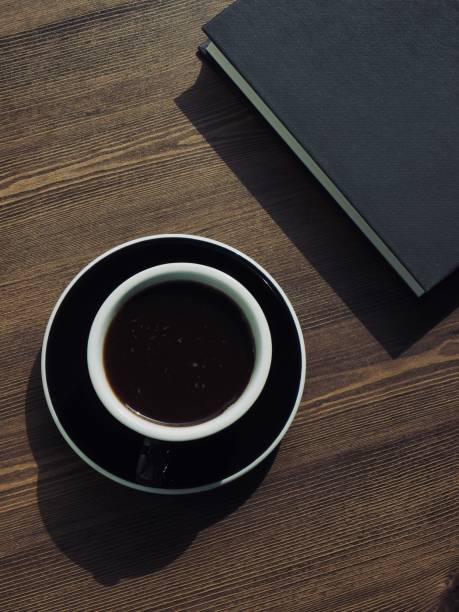 istock Wooden board background with coffee and black books 1147881650