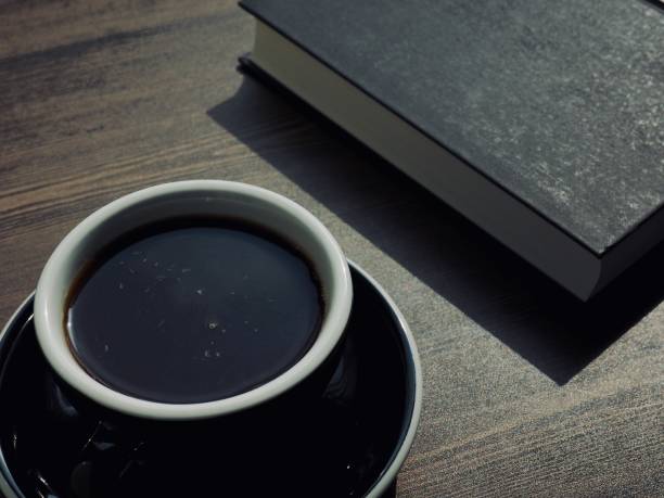 istock Wooden board background with coffee and black books 1147881651