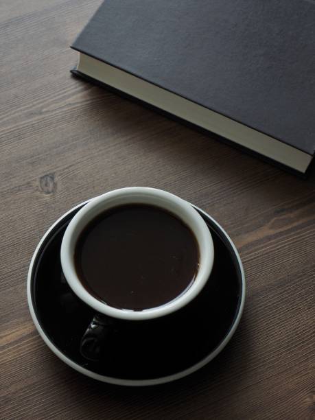 istock Wooden board background with coffee and black books 1147881665