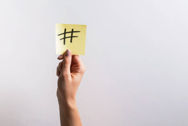 istock Woman's hand holding small paper with drawn hashtag symbol on it 1147881688