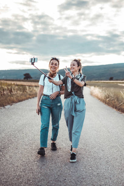 szczęśliwi przyjaciele z kijem do selfie filmujący swoją przygodę - travel adolescence road trip outdoors zdjęcia i obrazy z banku zdjęć