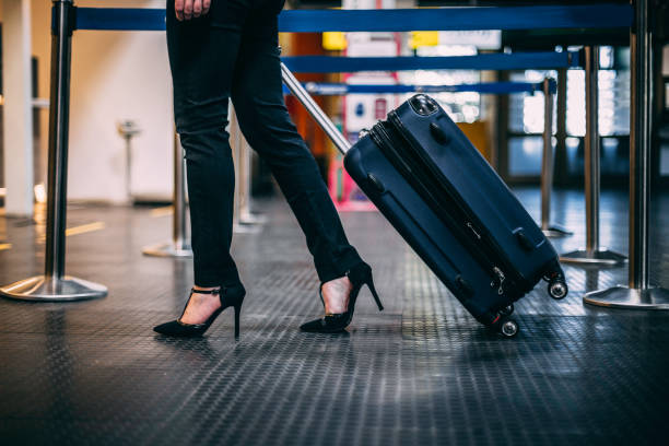 istock Woman pulling suitcase at the airport 1147884132