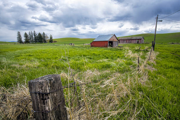istock Fence leads to old red barn in Washington. 1147887513