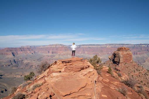 Young woman travels in USA and contemplates the famous Grand Canyon, United States, people travel explore nature