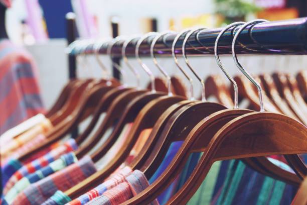 istock Colorful shirts hanging on rack close up 1147888359