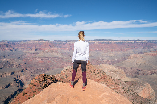 Young woman travels in USA and contemplates the famous Grand Canyon, United States, people travel explore nature