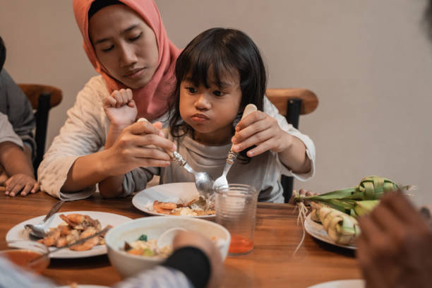 istock muslim mom eat with her daughter sitting on lap 1147890451
