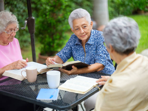 istock Lovely elderly women reading books and talking 1147891359