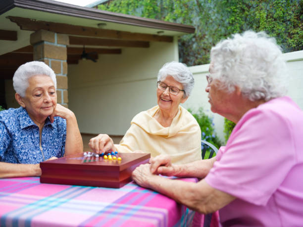 istock Three elderly women playing chinese checkers outdoors 1147891399