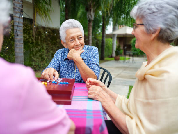 istock Playful elderly women playing with board game outdoors 1147891412