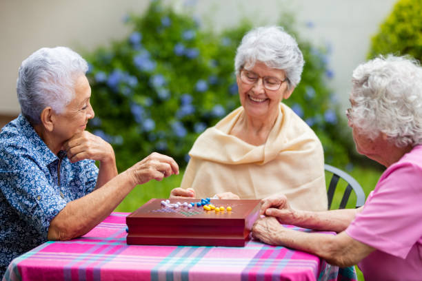 istock Happy elderly women playing chinese checkers outside 1147891416
